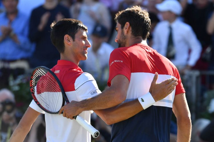 Croatia's Marin Cilic (R) embraces Serbia's Novak Djokovic after winning the men's singles final at the ATP Queen's Club Championships tennis tournament in west London on June 24, 2018. - Cilic won the final 5-7, 7-6, 6-3. (Photo by Ben STANSALL / AFP) (Photo credit should read BEN STANSALL/AFP/Getty Images)