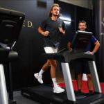 Stefanos Tsitsipas exercises on a treadmill backstage at the Palexpo