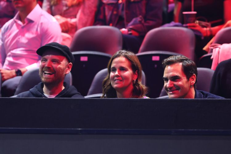 Coldplay guitarist Jonny Buckland, former WTA player Mary Joe Fernandez and Roger Federer in the stands. Photo by Clive Brunskill/Getty Images.