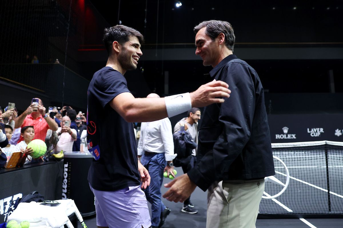 Roger Federer and Carlos Alcaraz catch up at a Team Europe practice session on the practice court.