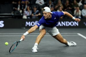 Mensik reaches for a low backhand.