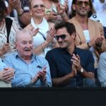 Roger Federer joins Rod Laver to watch the action on center court.