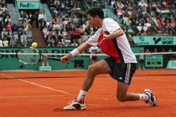 Tim Henman slides into a backhand during his semifinal match against Guillermo Coria at Roland Garros 2004. 